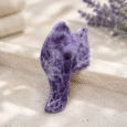 Amethyst Fish Tail Gua Sha beside towels and facial oil